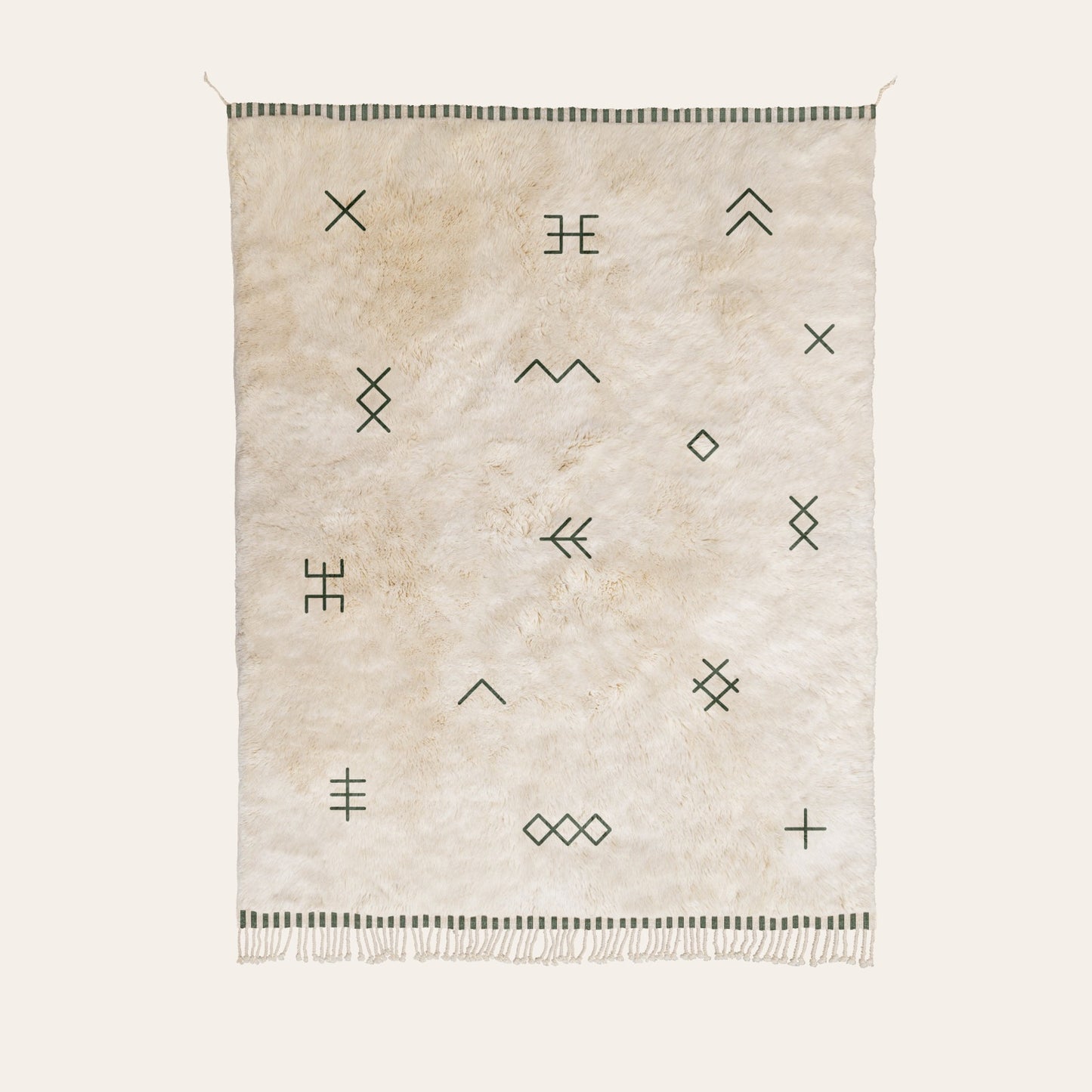Natural wool rug with geometric patterns in forest green on a white background